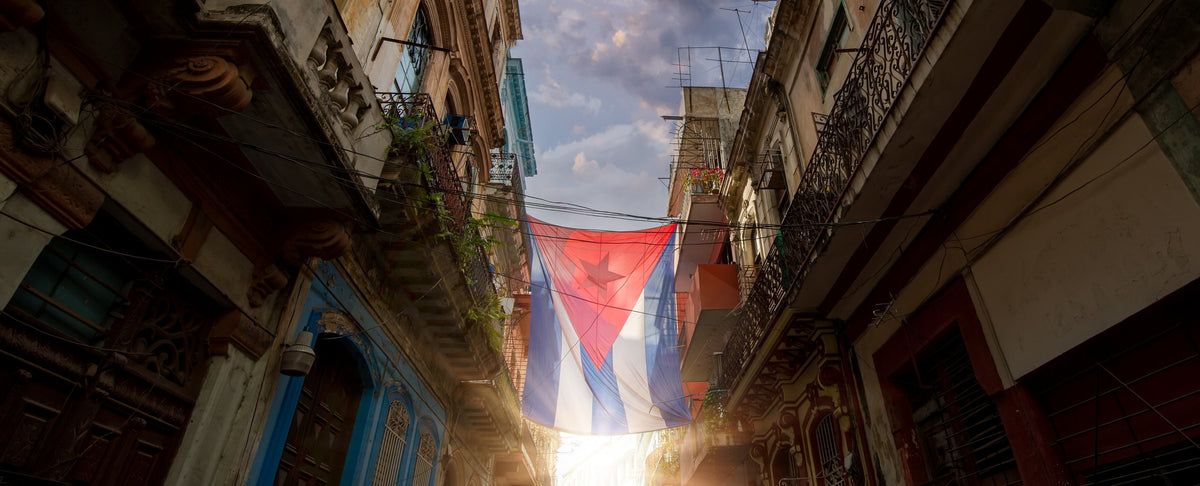A street in Old Havana with the Cuban flag and warm evening light